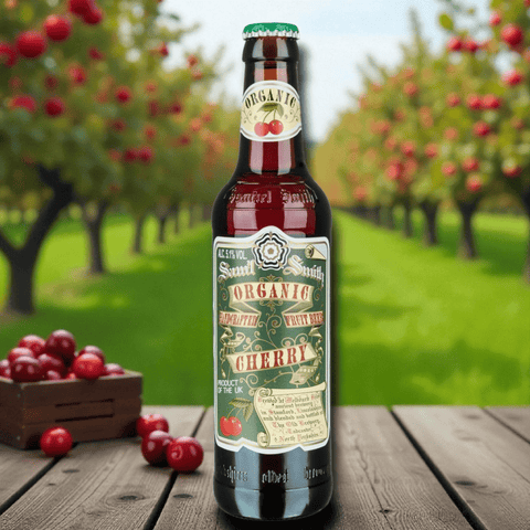 Samuel Smith’s Organic Cherry Ale 355 ml Flasche auf Holzuntergrund vor Kirschbaum, Bio-Kirschbier aus Großbritannien